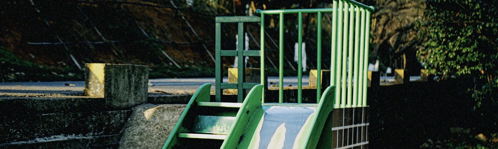 A set of stairs and a metal children’s slide on a playground