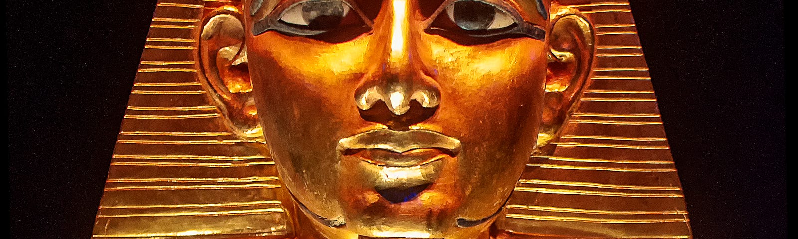 A picture of a golden bust of an egyptian Pharoah