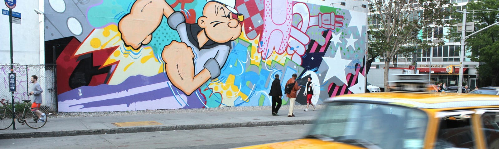 yellow taxi with street art behind