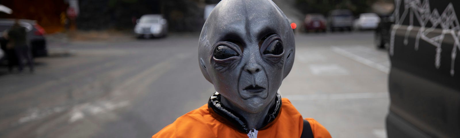 space alien in a fine orange jacket