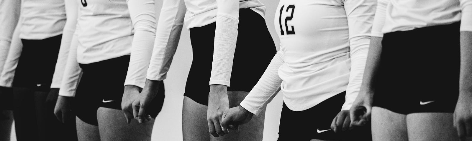 A volleyball team holding hands