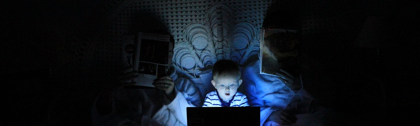 Little child watching a screen at night