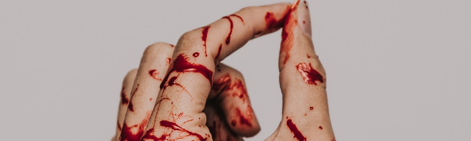 A bloodied hand holding a match.