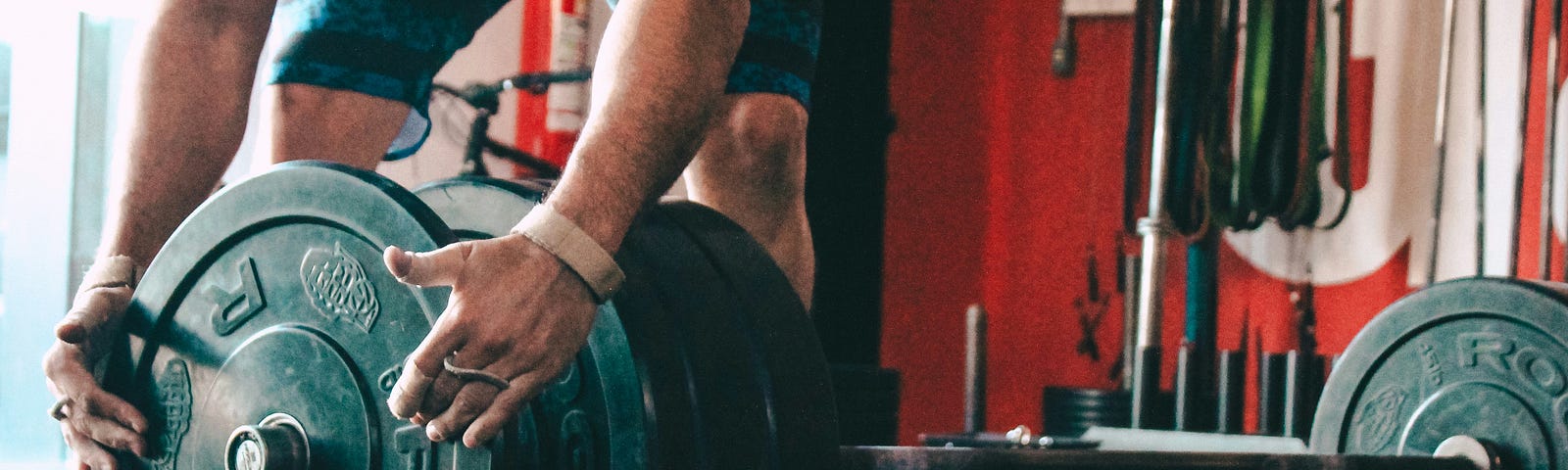 Man adjusts a weight on a barbell.