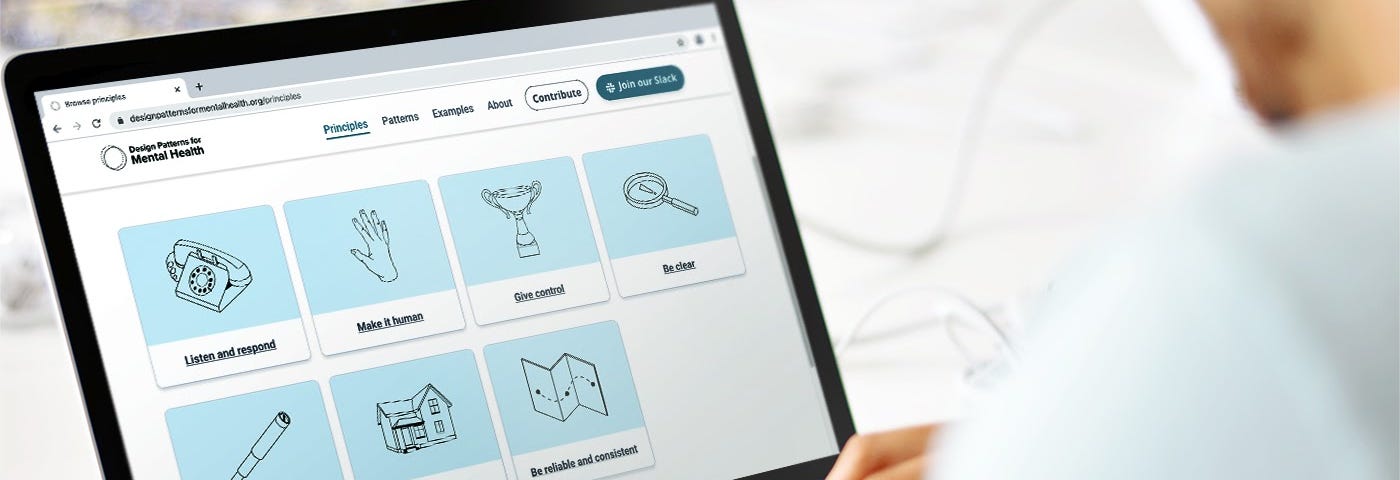 A visual of the design patterns for mental health library on a laptop as a white person types at the screen