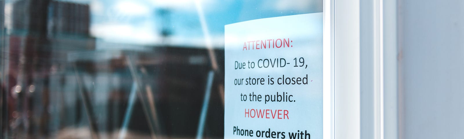 [Photo] Window with a sign announcing that due to COVID-10, they are closed to the public and offering curbside pickup.