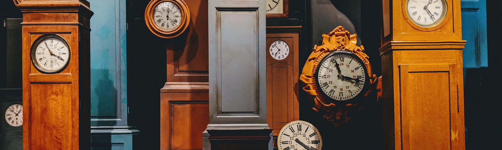 A photo of several grandfather clocks.