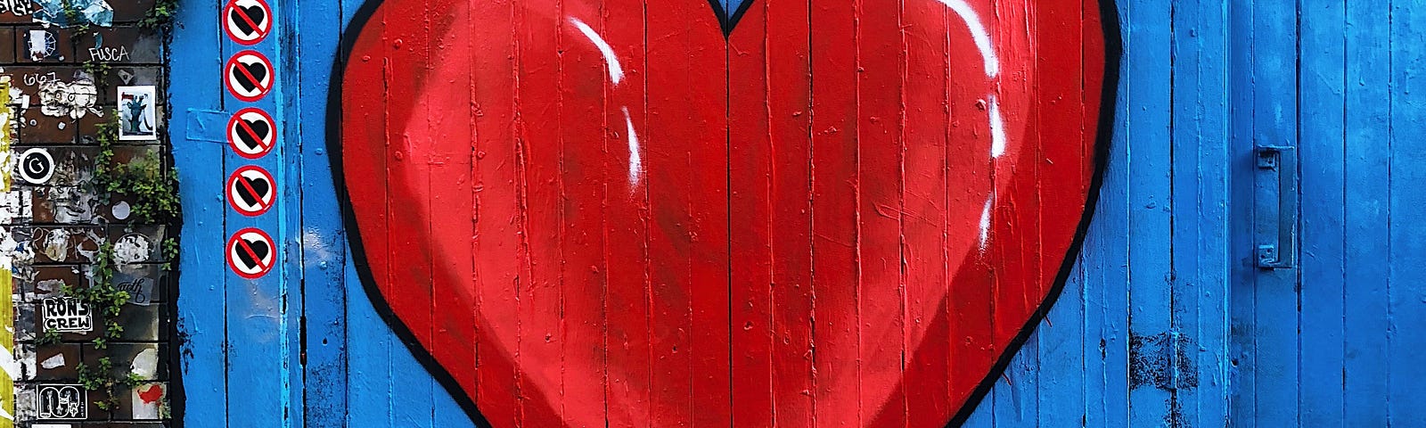 A large heart painted on a pair of old wooden doors.