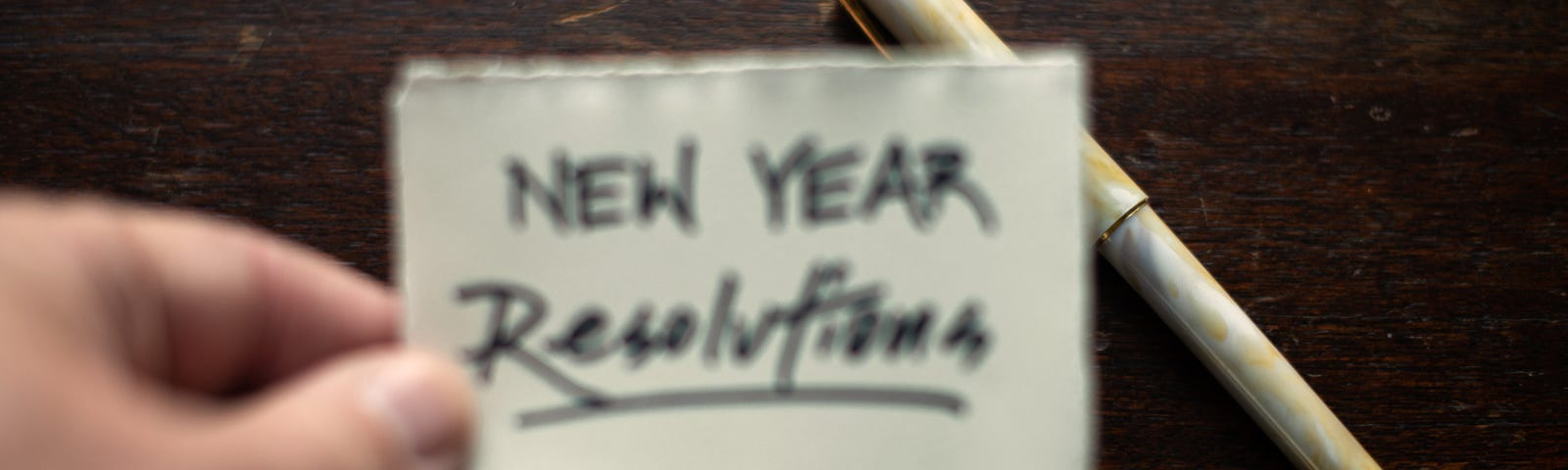 Image of a card that is being held that says “New Year Resolutions”