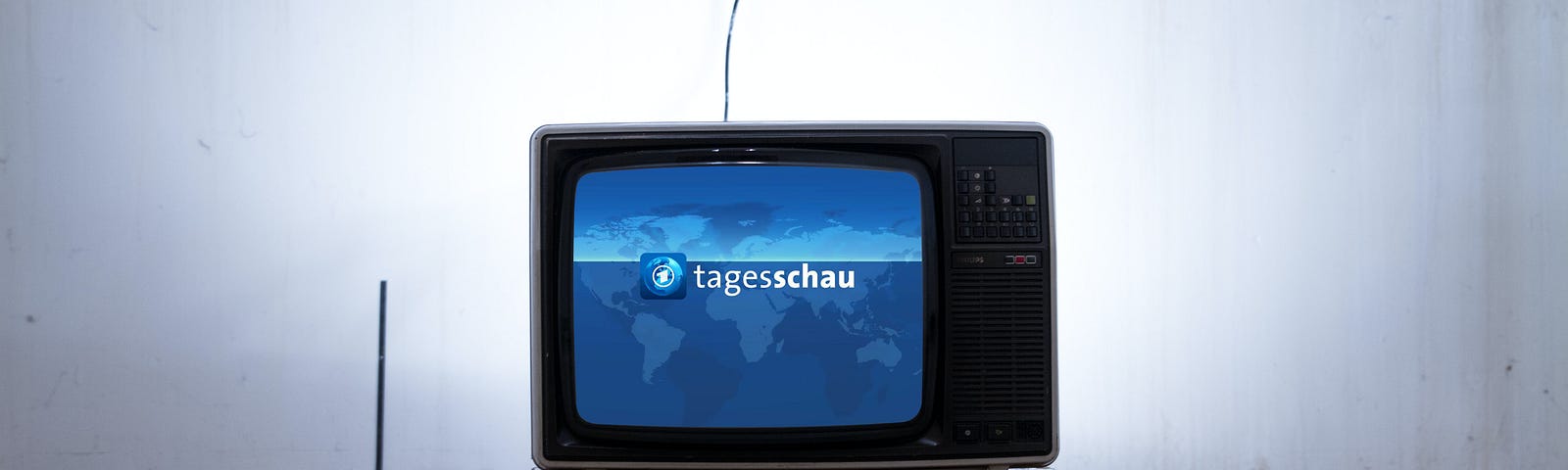 Television in empty room with blue screen and words “Tagesschau”