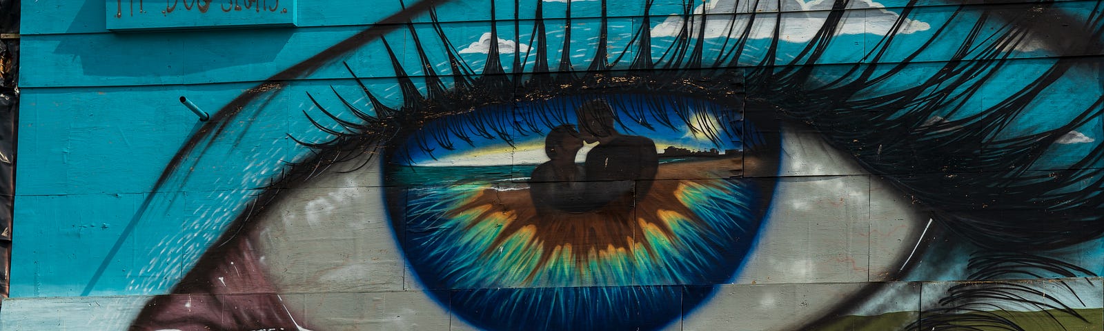 Colorful painting of an eye on the side of a building. Blue and green palette. Glaucoma is a leading cause of blindness.