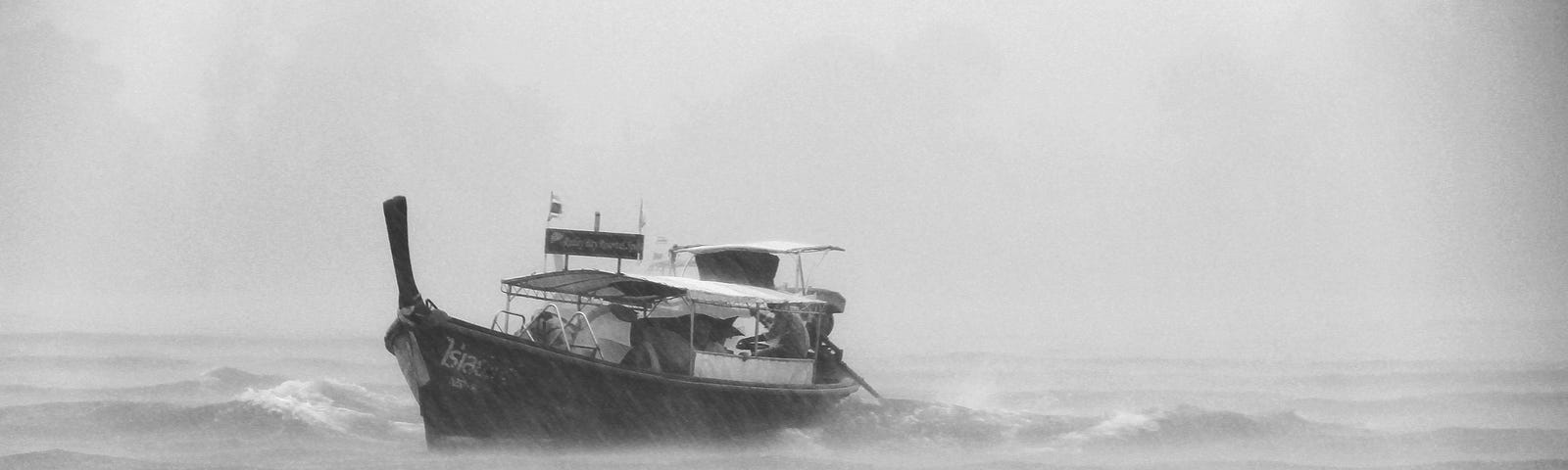 A small fishing boat is caught in a rain storm at sea.