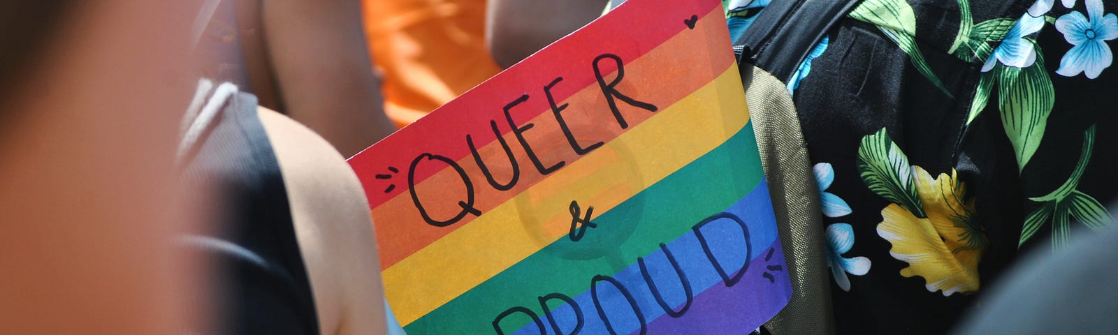 a pride flag with the words Queer and Proud