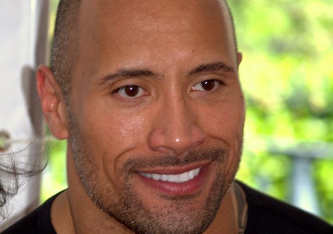 Photo of Dwayne “The Rock” Johnson wearing a black and having hair.