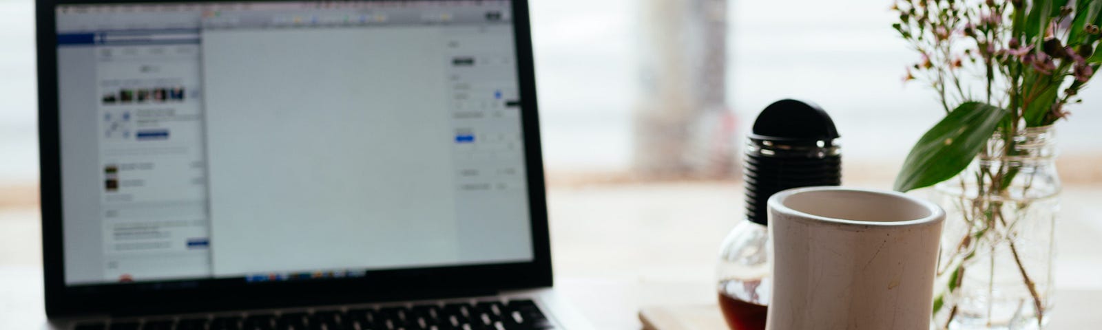 Photo of a notebook in front of a laptop, on a desk.