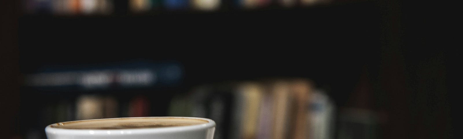 Coffee cup sitting next to an open book on a table