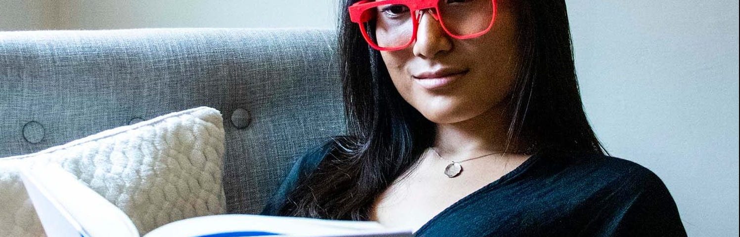 Woman wearing AttentivU glasses while reading a book.