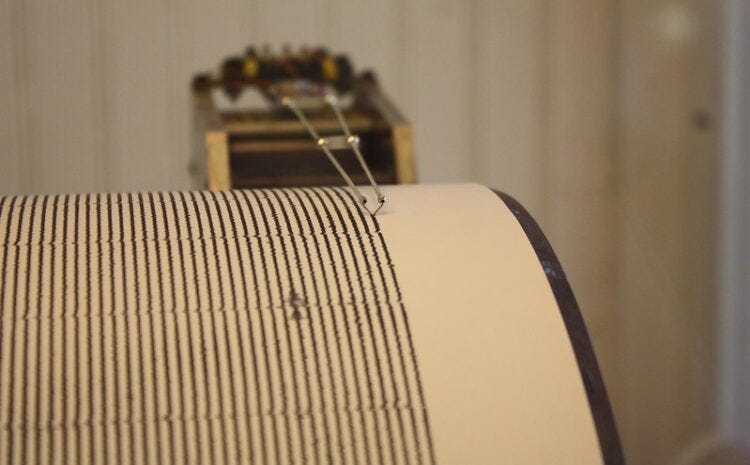 Old looking seismograph machine showing a stable series of lines on a scroll