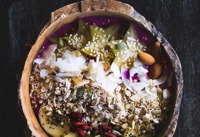 Bowl of healthy food with banana, coconut, nuts, seeds