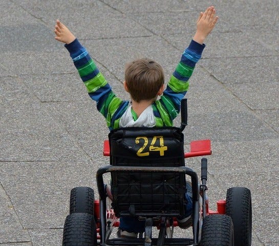 Child raising arms in victory after go cart race