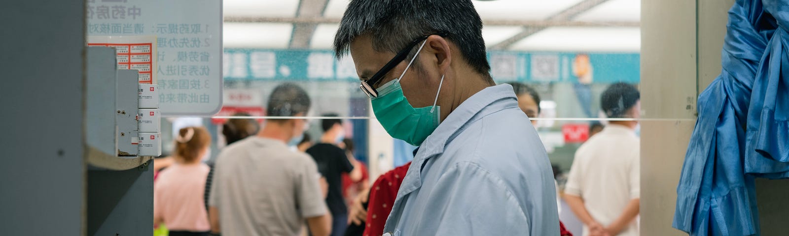 A medical doctor standing in the office consulting his notes.