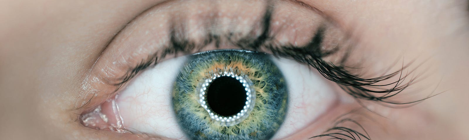 A close up image of a woman’s green eyes that seem to show matrix codes inside.