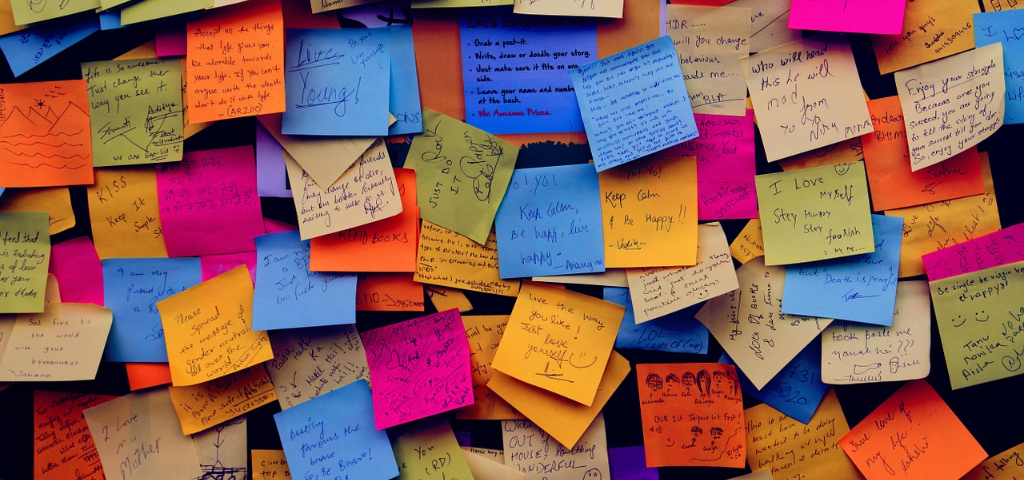 Wall covered in multicolored sticky notes with appreciative messages on them.