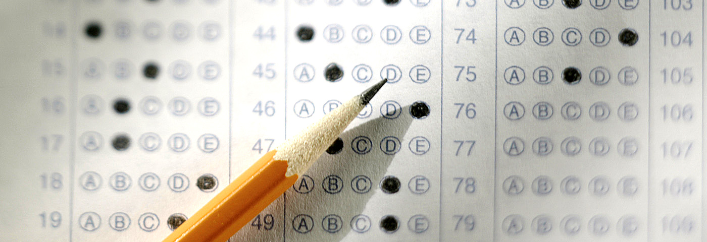 A wooden pencil laying on top off a filled-out scantron.