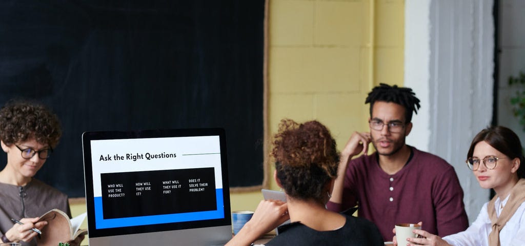 a team of three ladies and one man in a meeting