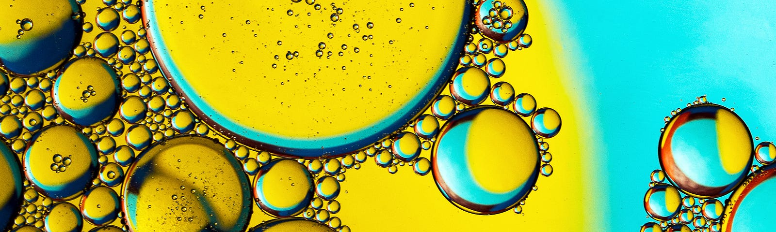 Olive oil bubbles in close-up, on a yellow and blue background. A recent study shows an association between olive oil consumption and longer life.