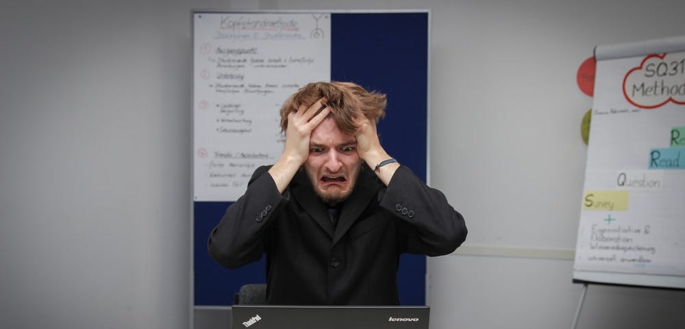 Man distressed in front of laptop