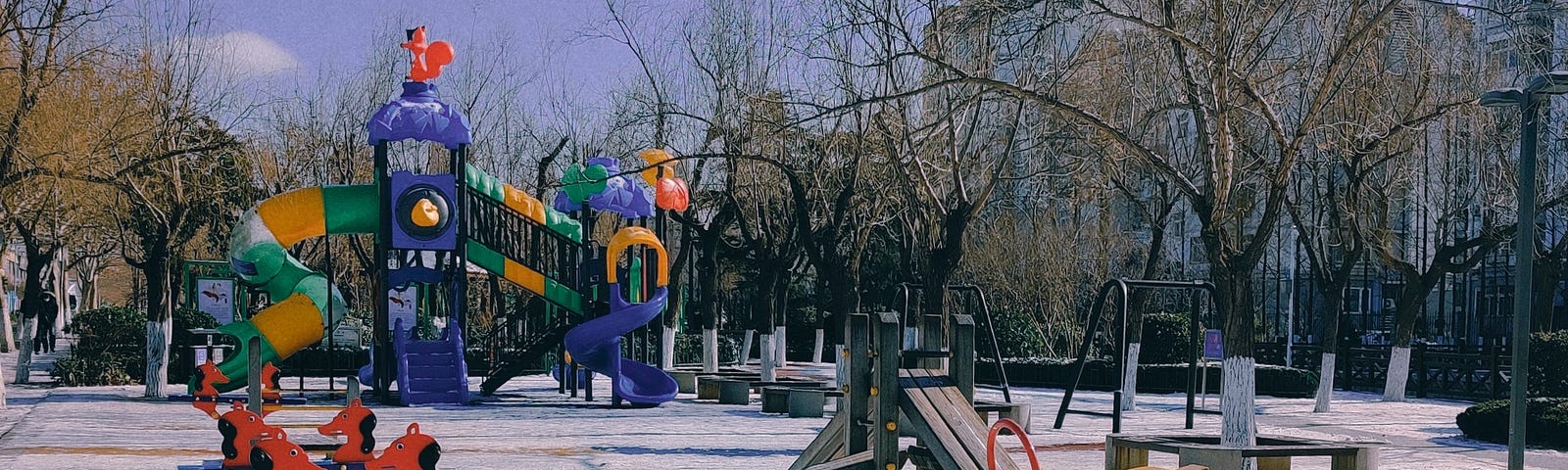 A playground in winter with seesaws and other equipment to play on