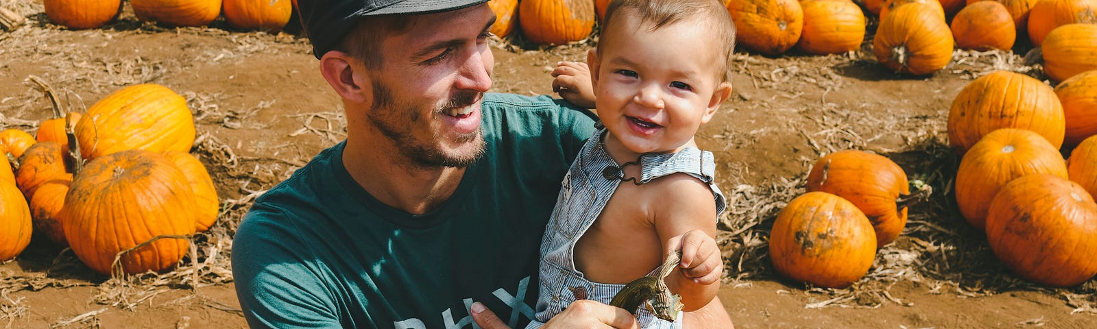 A father and child with the child wearing an overall