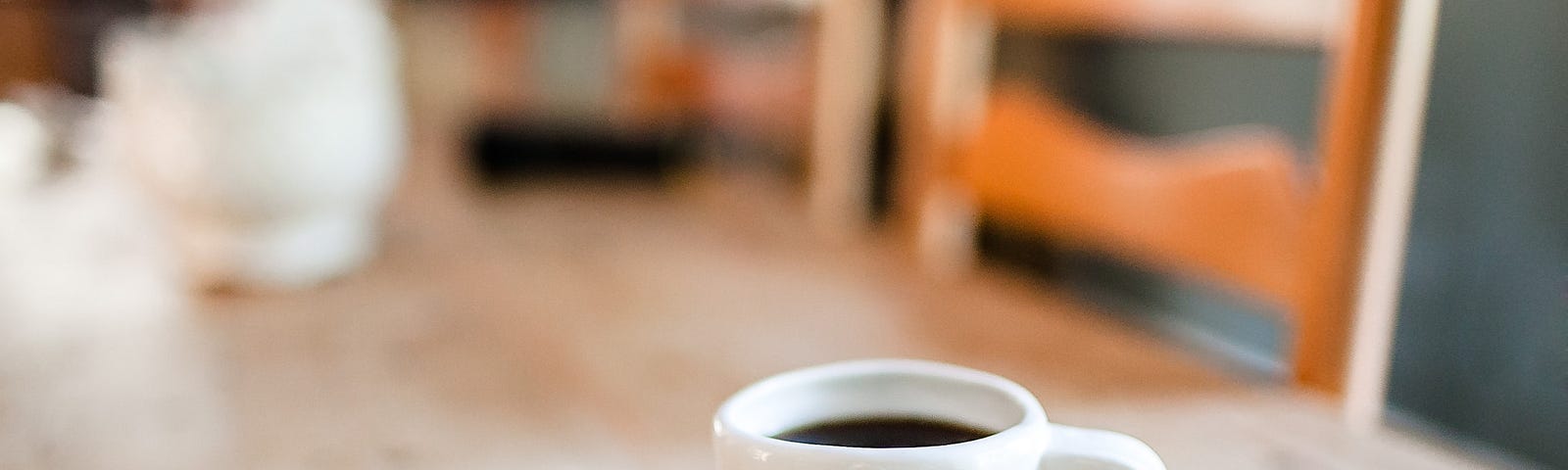 coffee cup on a wood table with the inscription “begin”