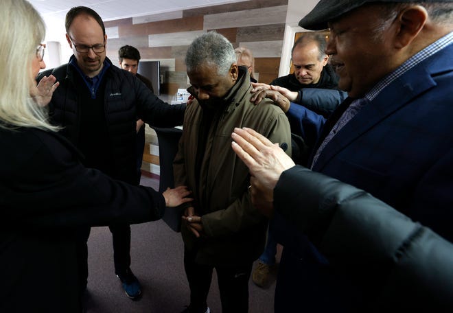 M. Dujon Johnson of Detroit is surrounded by friends as they pray over him at Church of the King in Berkley on Friday, March. 4, 2022. Johnson says he is heading to Ukraine on Wednesday to fight on the front lines against the Russian invasion.