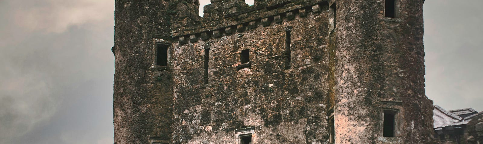 Crumbling, old castle against a grey sky.