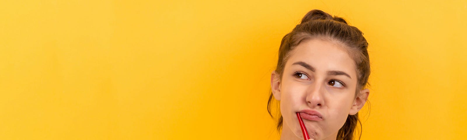 A young woman brushing her teeth with a toothbrush