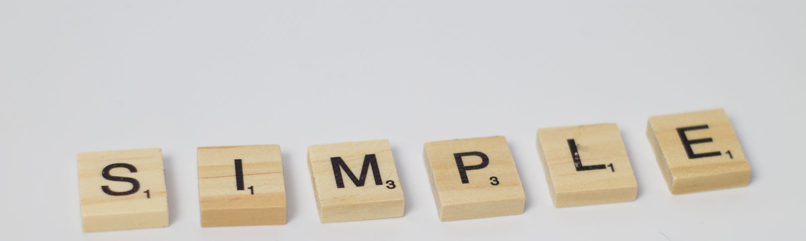 Scrabble letter blocks are lined up to spell “simple”