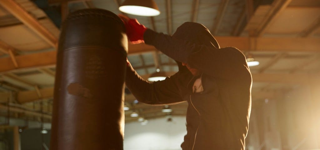 a man knees a punching bag