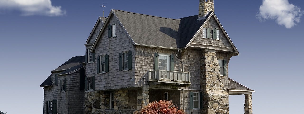 Picture of a two-story house with stone siding.