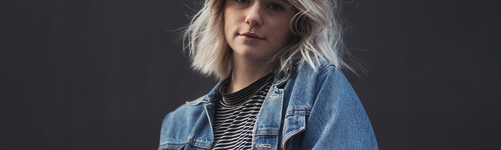 A young white girl of about 14 years old wearing a jean jacket.