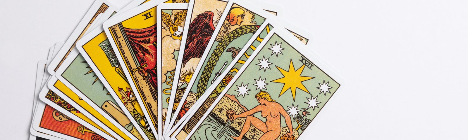 A selection of Rider Waite Smith Tarot Cards fanned out with The Star card on top.