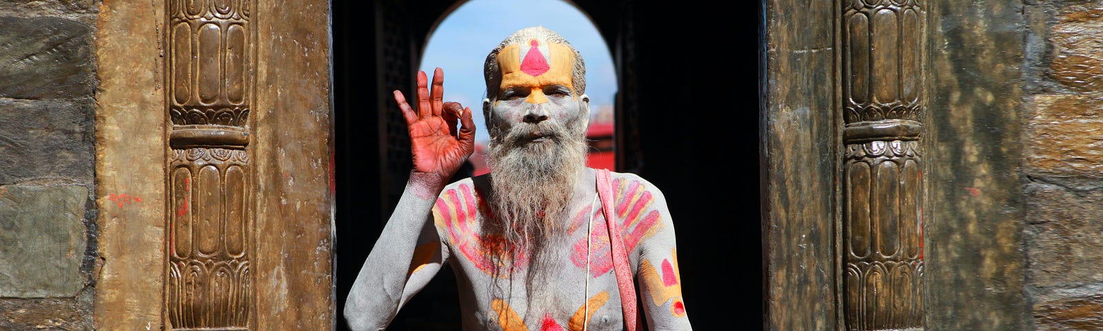 An old meditator from Nepal, covered in traditional body paint