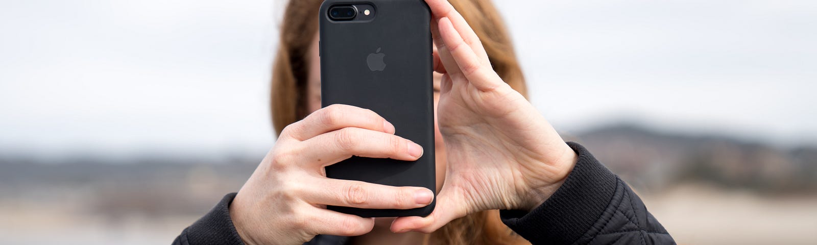 Woman taking photo using black iPhone 8 Plus