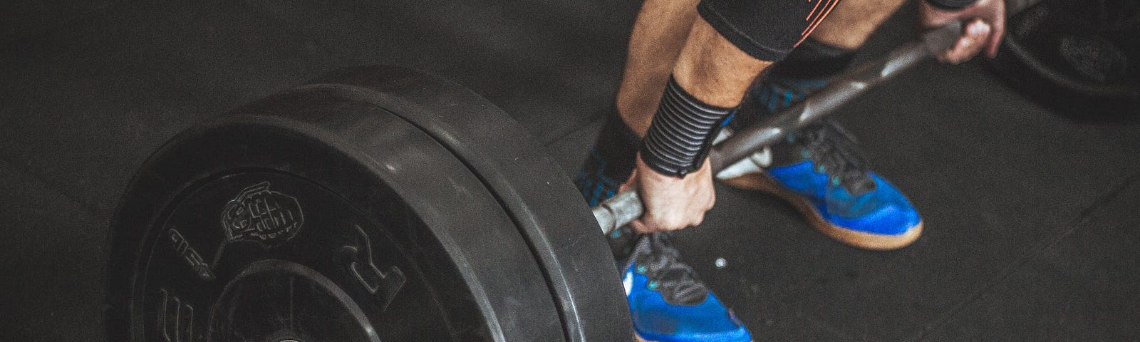 man lifting heavy barbell with weighted plates