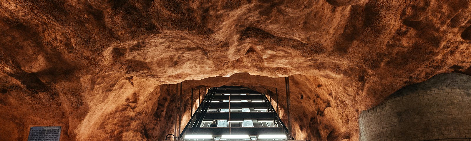 escalators in a rough-hewn rock cave