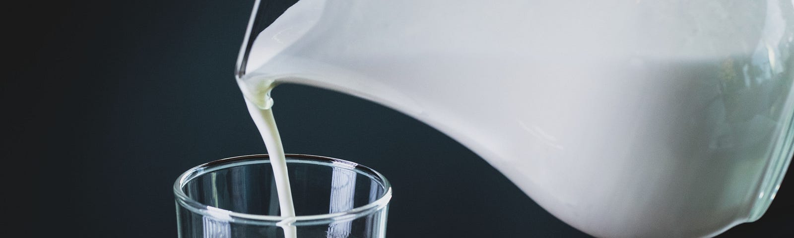 Pouring of milk from one jar to another. Article is about giving up milk.