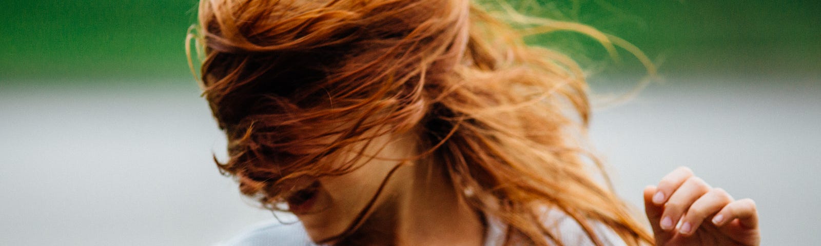 Wind blows a little girl’s hair back in her face.