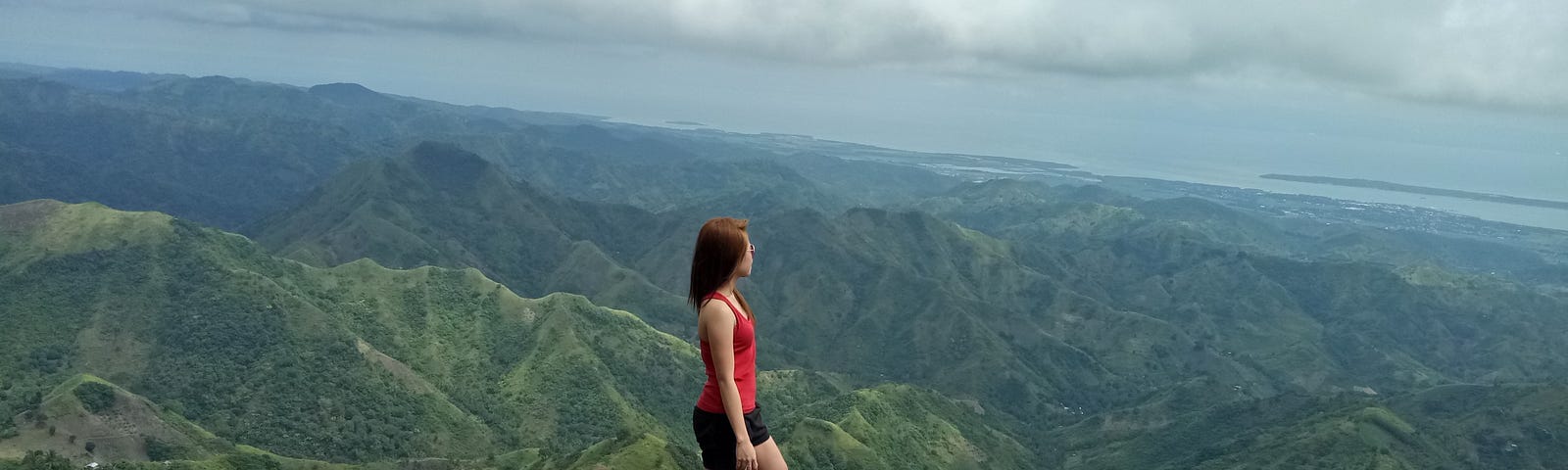 A woman standing on a peak of a mountain