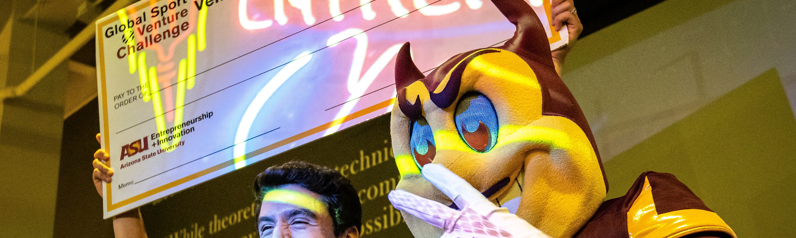 Aleksei Stojanovic, founder of GoSurf, poses at Venture Devils Demo Day with ASU mascot and giant check